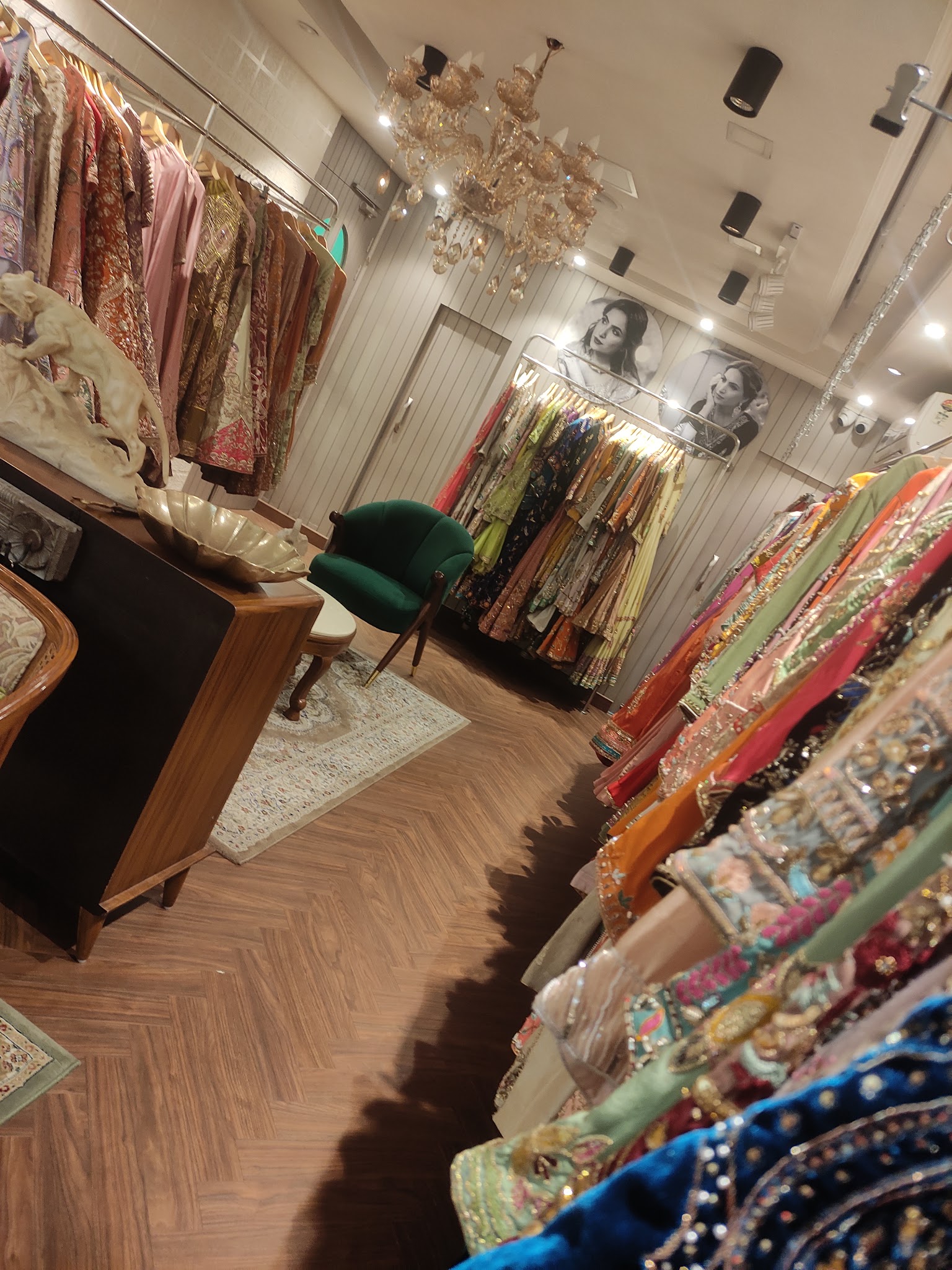A fashion boutique interior with colorful garments and a chandelier